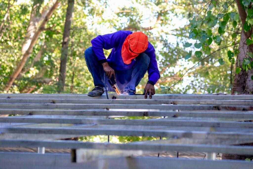 A man welding metal trusses