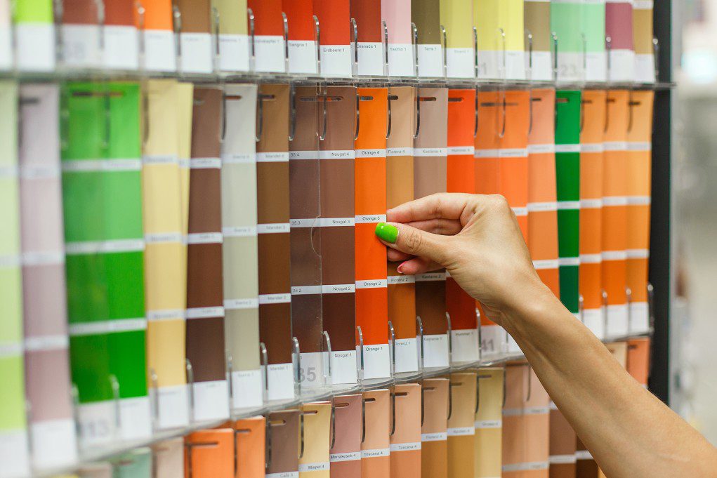 A woman selecting an orange color to complement her brown roof