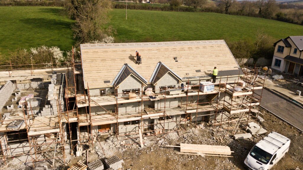2 roofers at the top of the roof